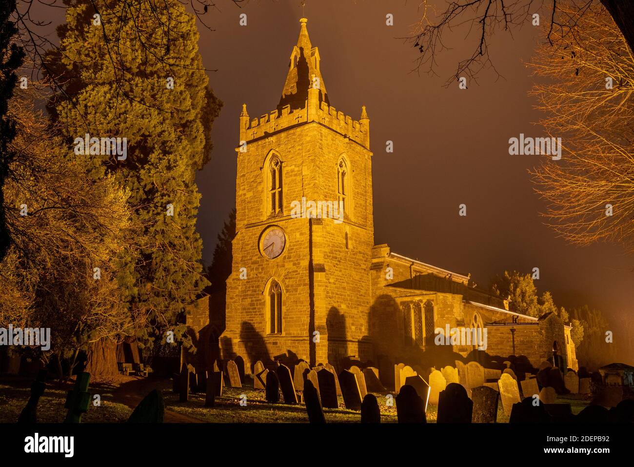 The church in Great Bowden on a dark foggy November night Stock Photo