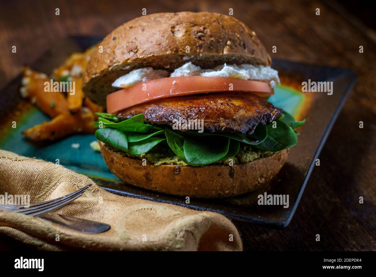 Portobello mushroom sandwich with goat cheese pesto and side of Greek sweet potato fries Stock