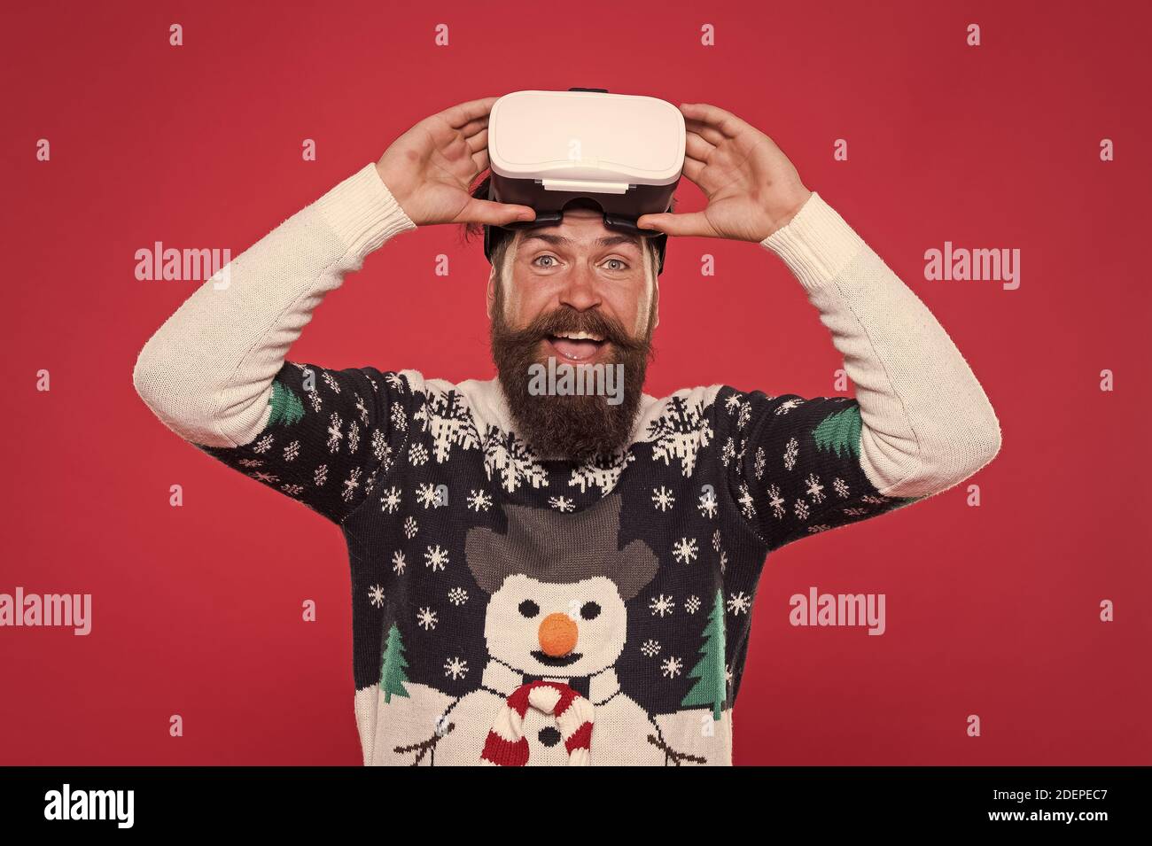 man winter sweater play game. indoor vs outdoor activity. Virtual reality. man wearing virtual reality goggles. xmas party. happy bearded hipster in vr glasses. interacting with a virtual environment Stock Photo