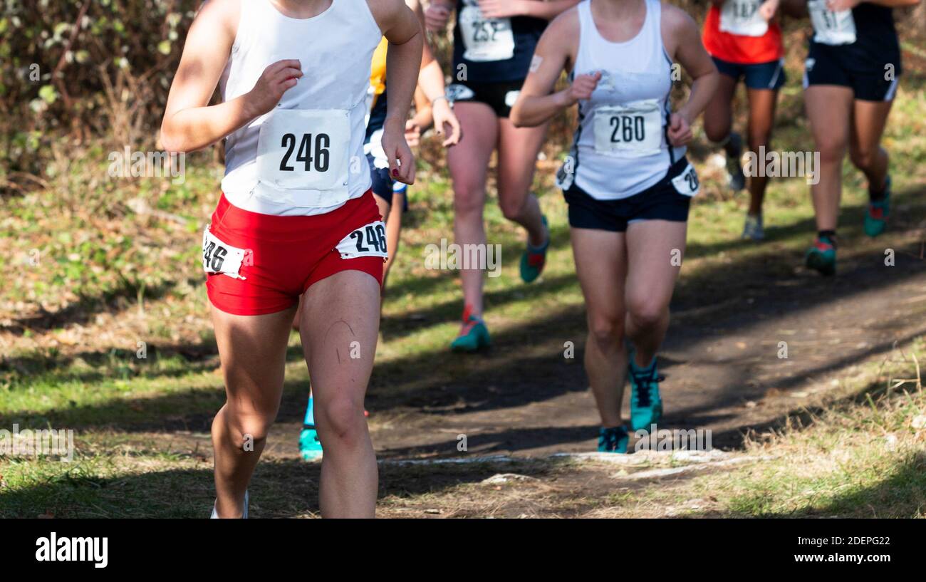 High school Cross country runners racing on a dirt path coming out of