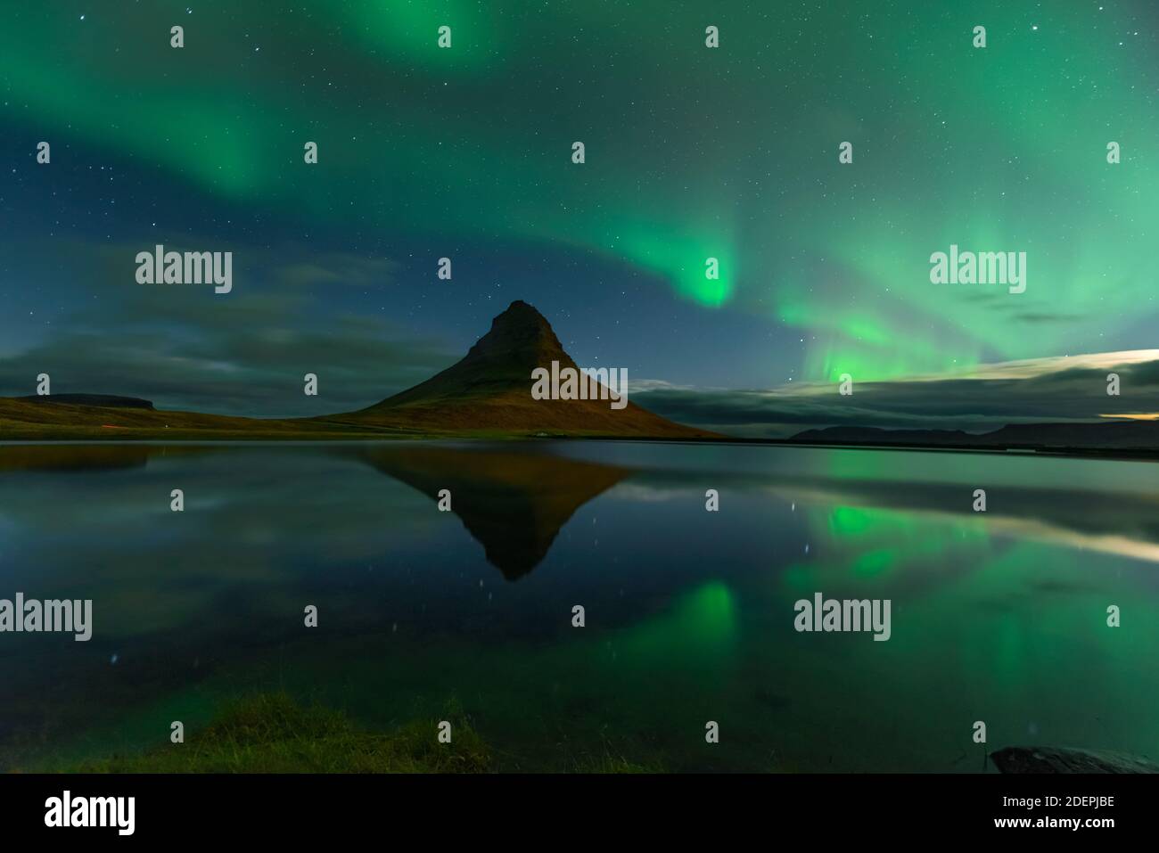 Northern lights in Iceland. Landscape full of kp5 Aurora Borealis. Amazing nightscape at Kirkjufell, scenic travel destination. Green sky full of star Stock Photo
