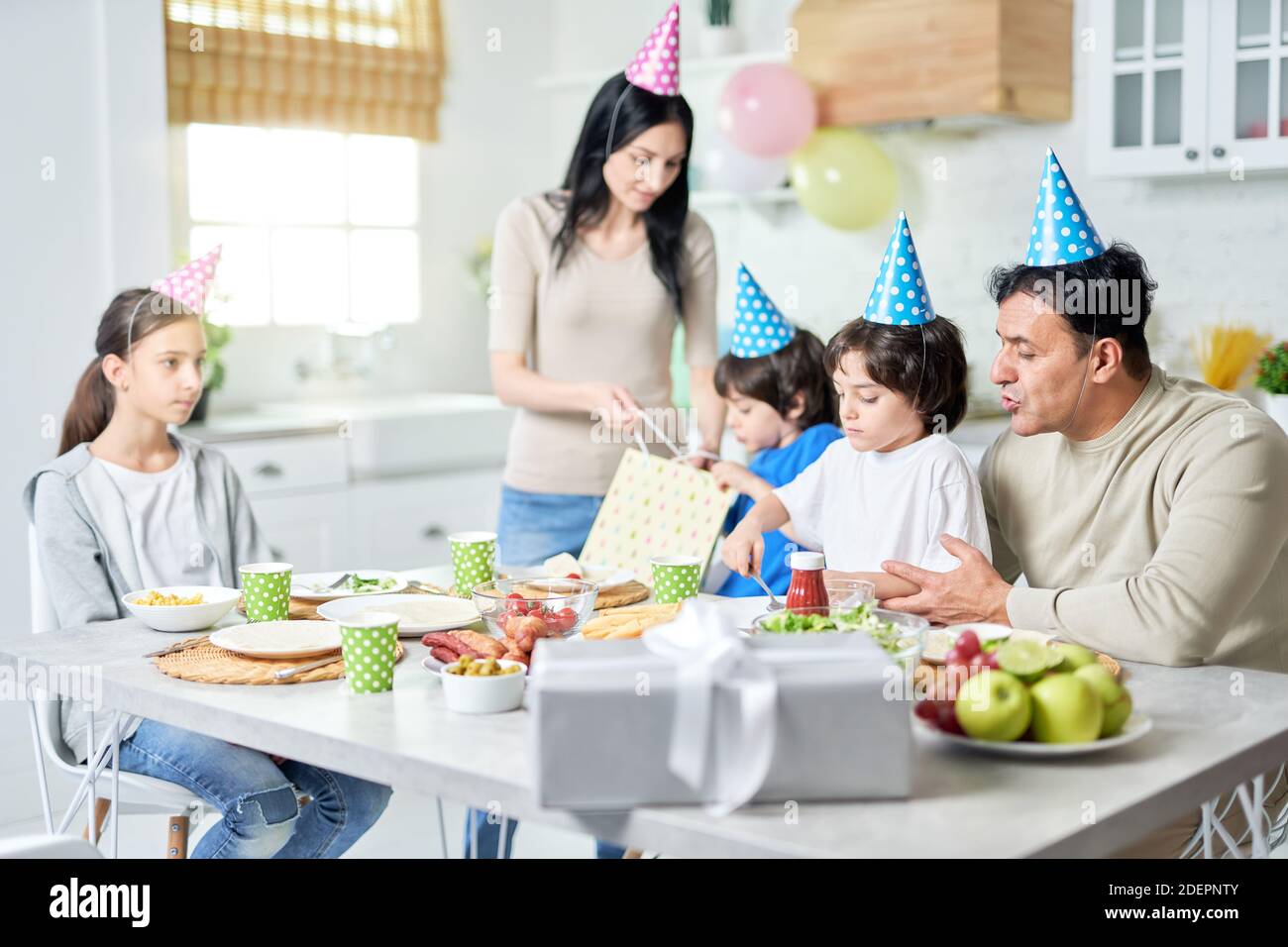 Happy hispanic family having dinner while celebrating birthday together at home. Parenthood, celebration concept. Selective focus Stock Photo