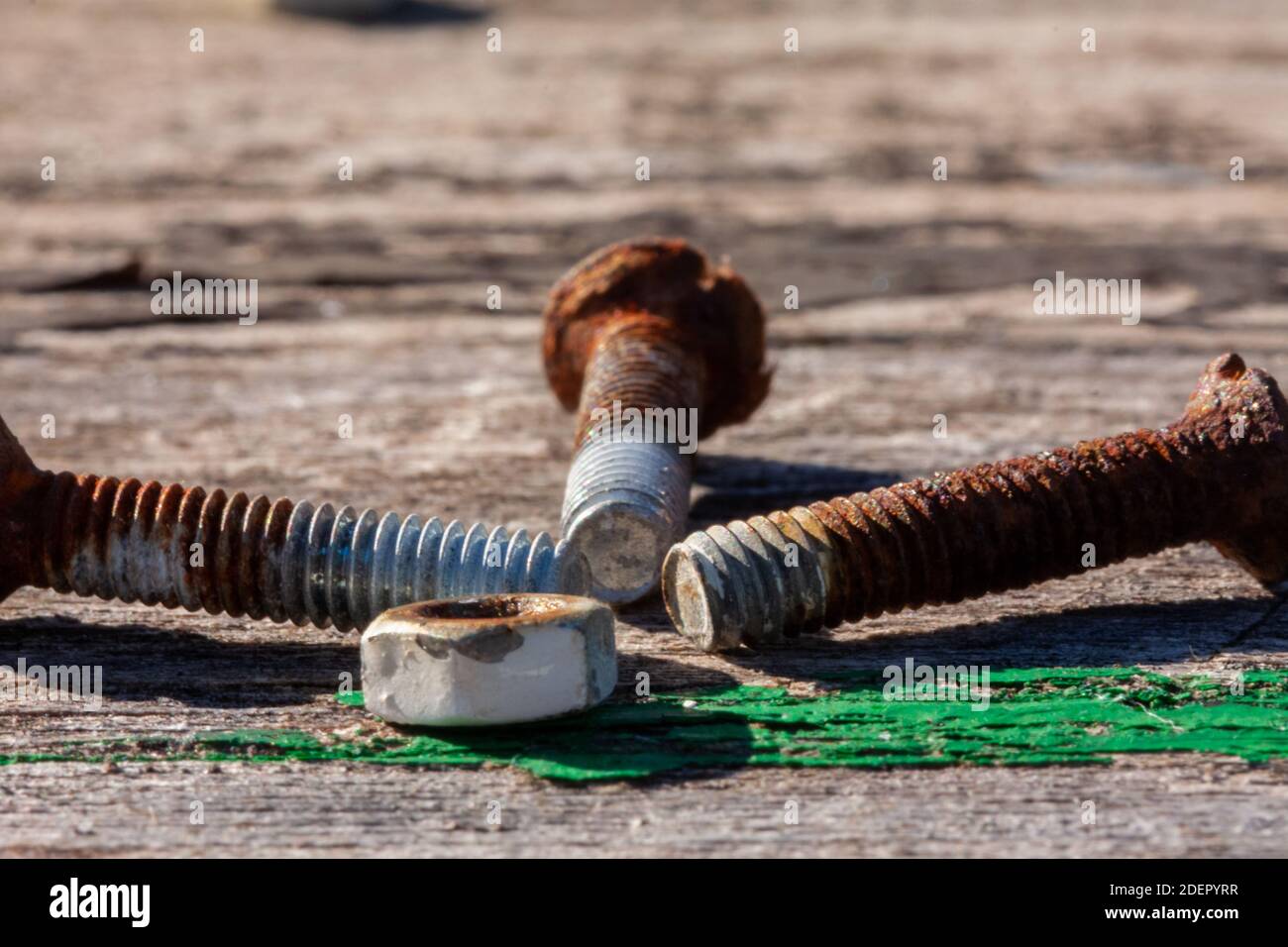 Old rusty nut and screws on a old wooden table. Stock Photo