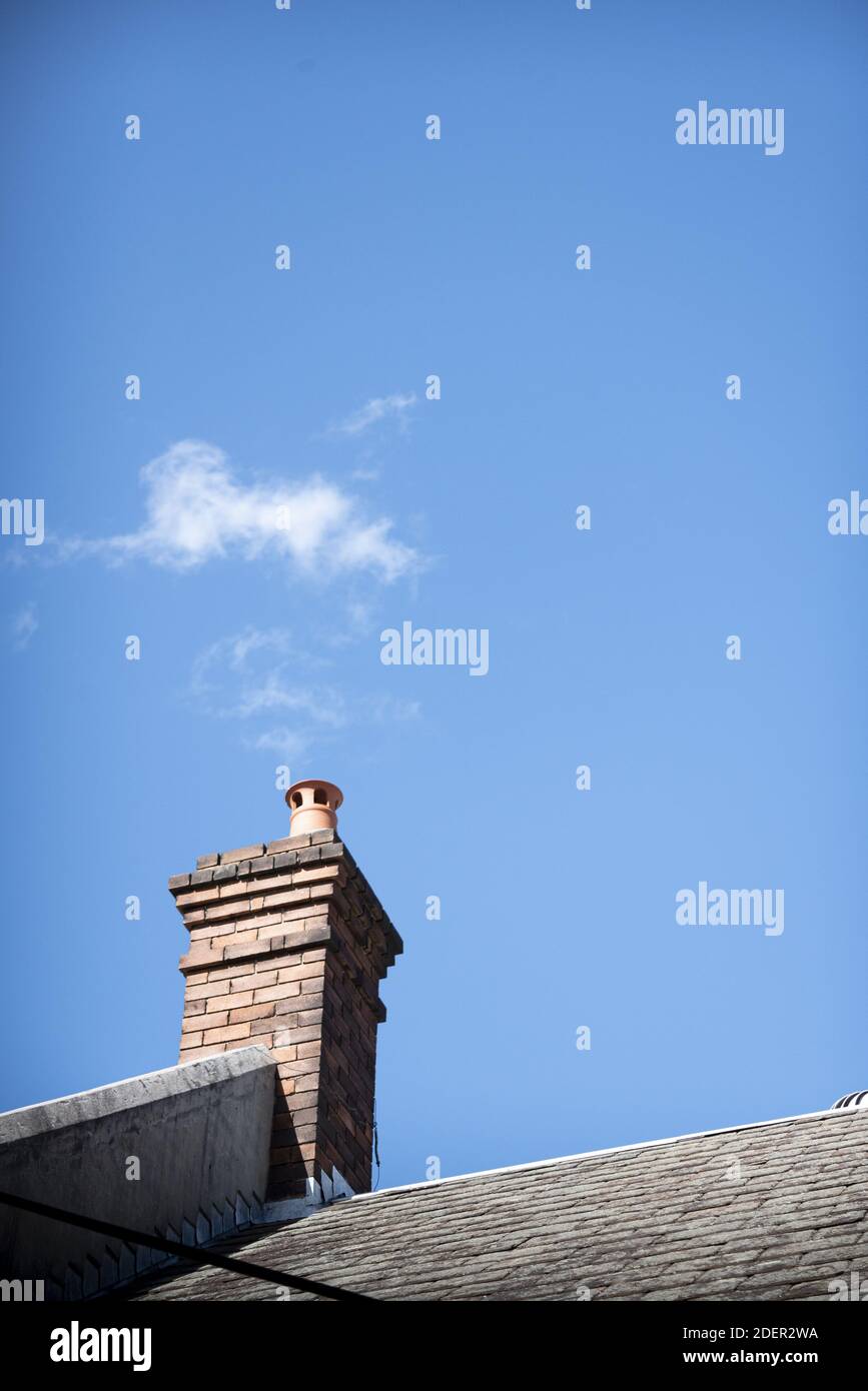 A vertical shot of a building chimney with clouds like smoke Stock Photo