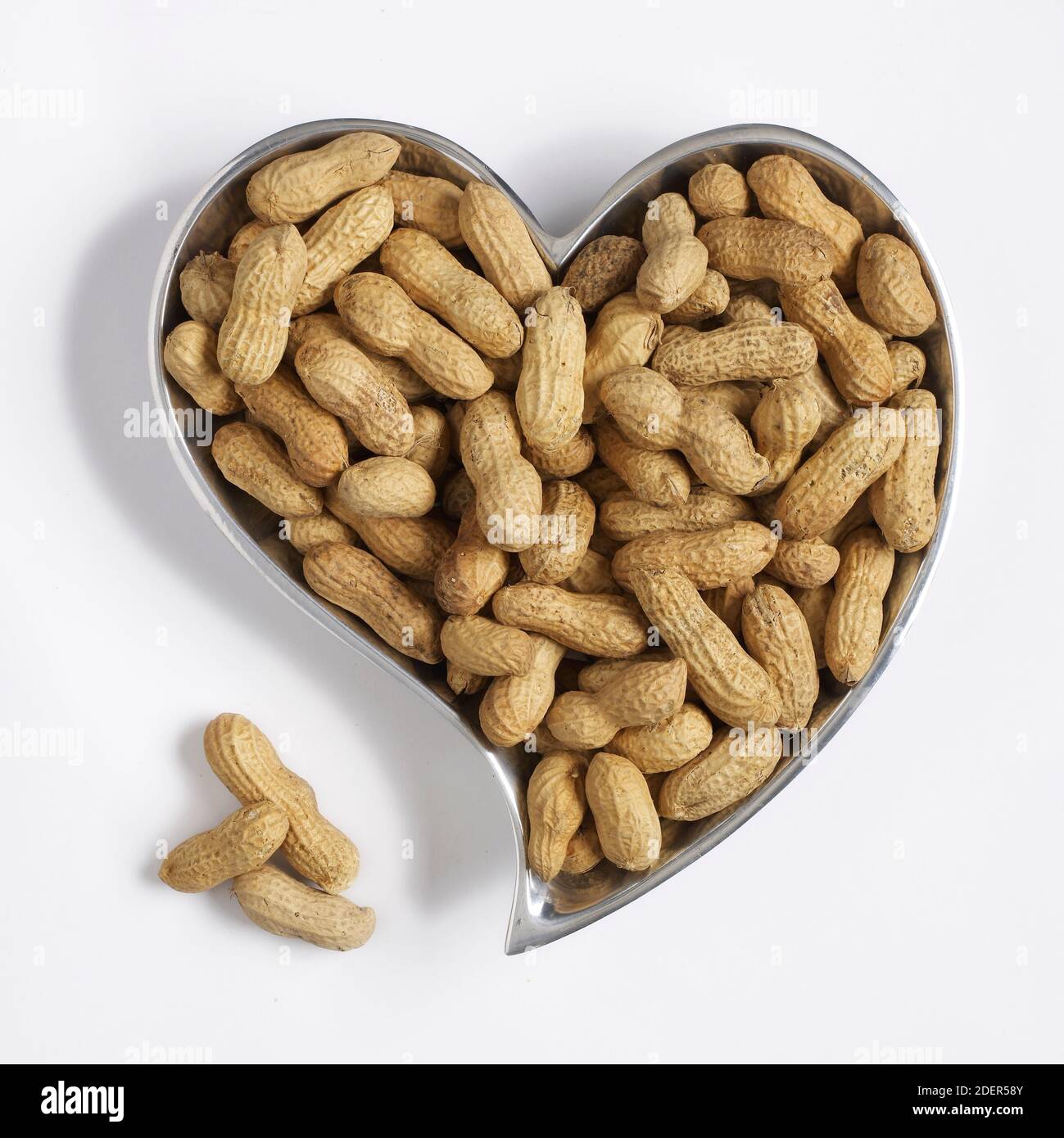 peanuts in heart-shaped container Stock Photo