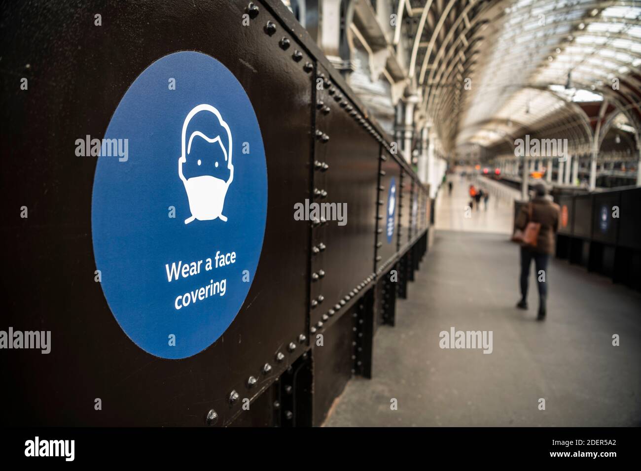 Coronavirus Covid-19 information sign saying wear a face covering mask at Paddington Train Station in London when public transport was quiet and deserted with no people in England, Europe Stock Photo