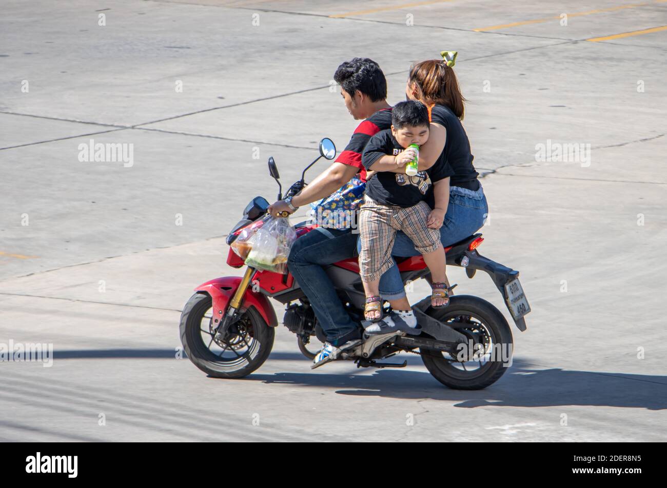 SAMUT PRAKAN, THAILAND, JUL 27 2020, The couple rides a motorcycle with a boy hanging in his mother's arms. Stock Photo