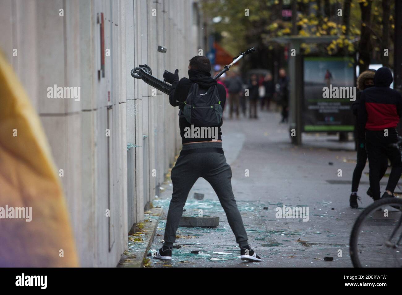 black blocs attack a building with a scooter on the place d'Italie in Paris  on November 16, 2019, during a demonstration of the "yellow vest" (gilets  jaunes) marking the first anniversary of