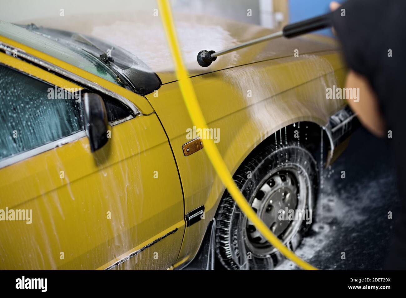 Cleaning hosing washing the car with high pressure water jet cleaner washer blaster in carwash system Stock Photo