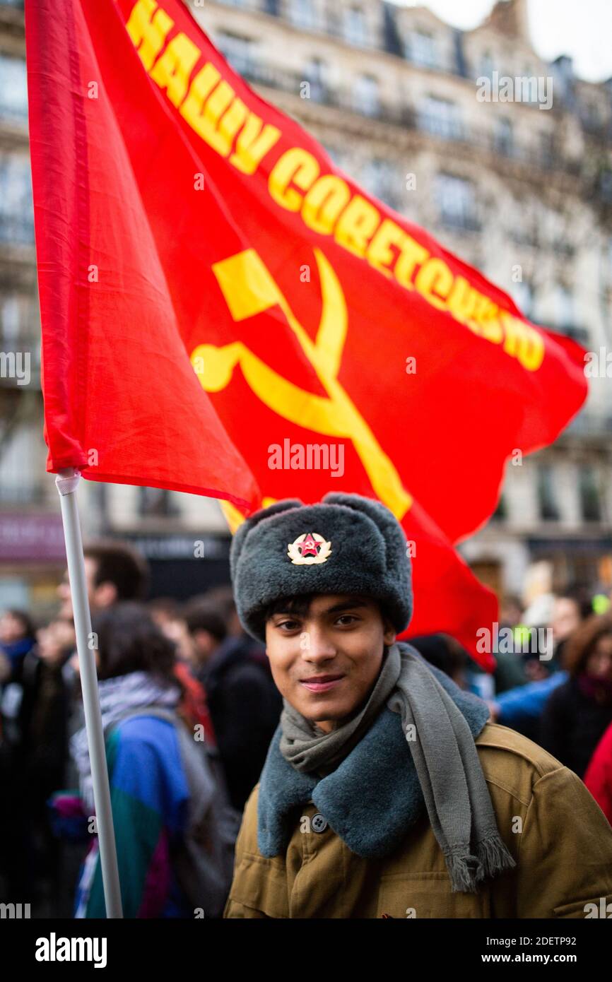 Protesters wearing red chapka and a communist flag during a demonstration  on December 10, 2019 in Paris, France, as part of the sixth day of massive  strike action over government's plans to