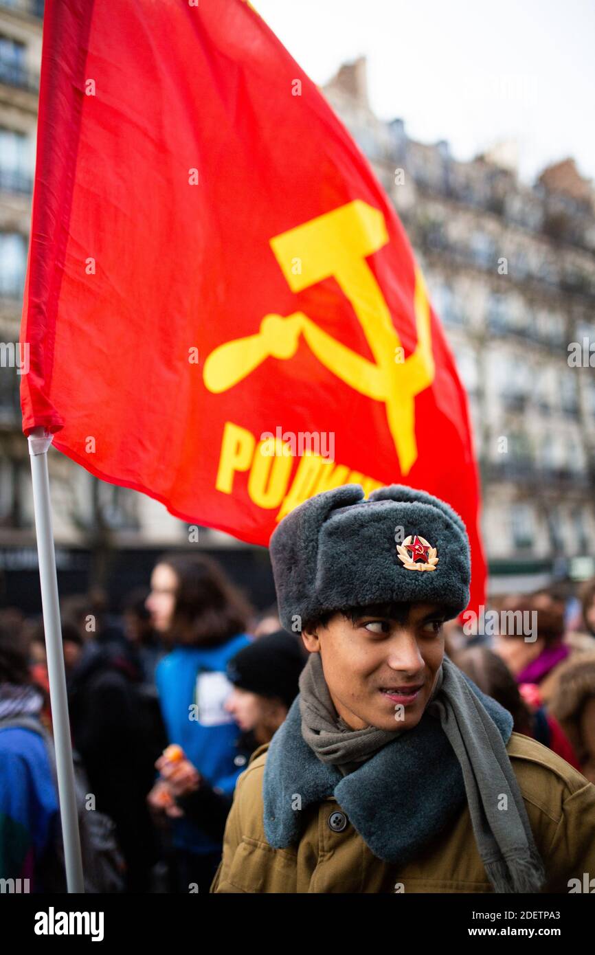 Protesters wearing red chapka and a communist flag during a demonstration  on December 10, 2019 in Paris, France, as part of the sixth day of massive  strike action over government's plans to