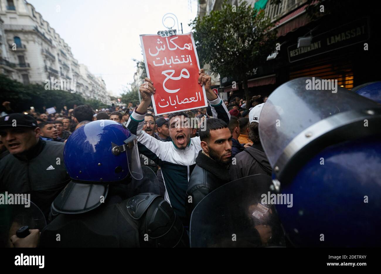 Algerian protesters take part in an anti-government demonstration in the capital Algiers on December 12, 2019 during the presidential election. Five candidates are running in Algeria's presidential election to replace ousted Algerian president Abdelaziz Bouteflika, the country's election authority said Saturday, amid widespread protests against the vote. Former premiers Ali Benflis and Abdelmadjid Tebboune are considered front-runners in an election opposed by the mass protest movement that alongside the army forced Bouteflika to resign in April after 20 years in power.No opinion polls have be Stock Photo