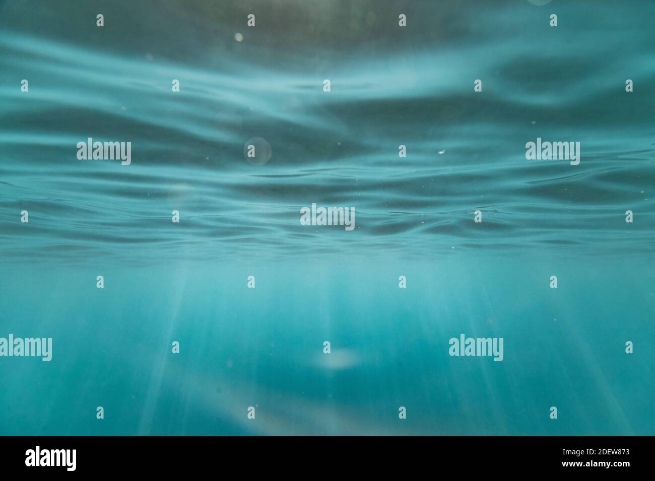 light streaks and textures underneath the ocean's surface in hawaii