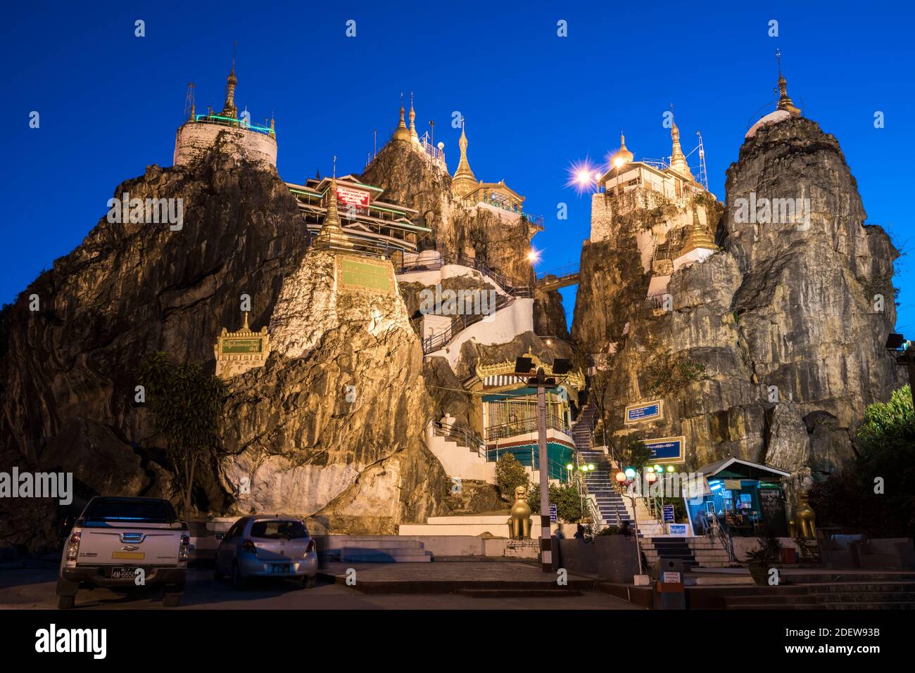 Illuminated Taung Kwe Pagoda against clear blue sky at twilight, Loikaw, Myanmar Stock Photo