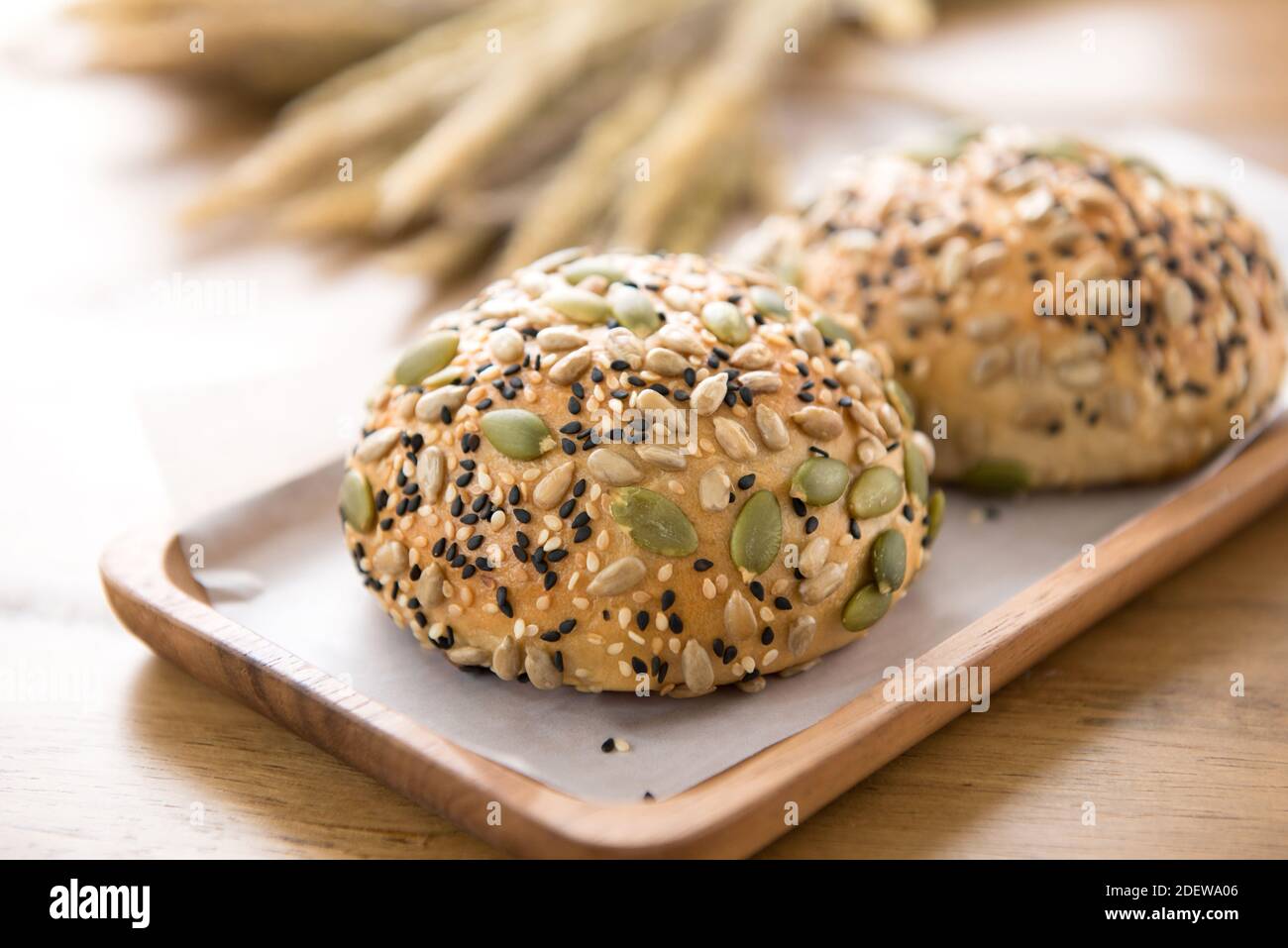Multigrain mixed cereal seed healthy bread bun in wooden plate displaying on the table Stock Photo