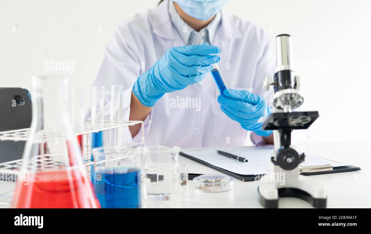 Young Asian scientist Working looking through a microscope doing ...