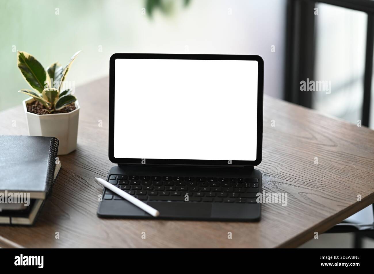 Mockup image of blank screen tablet computer, notebooks and houseplant ...