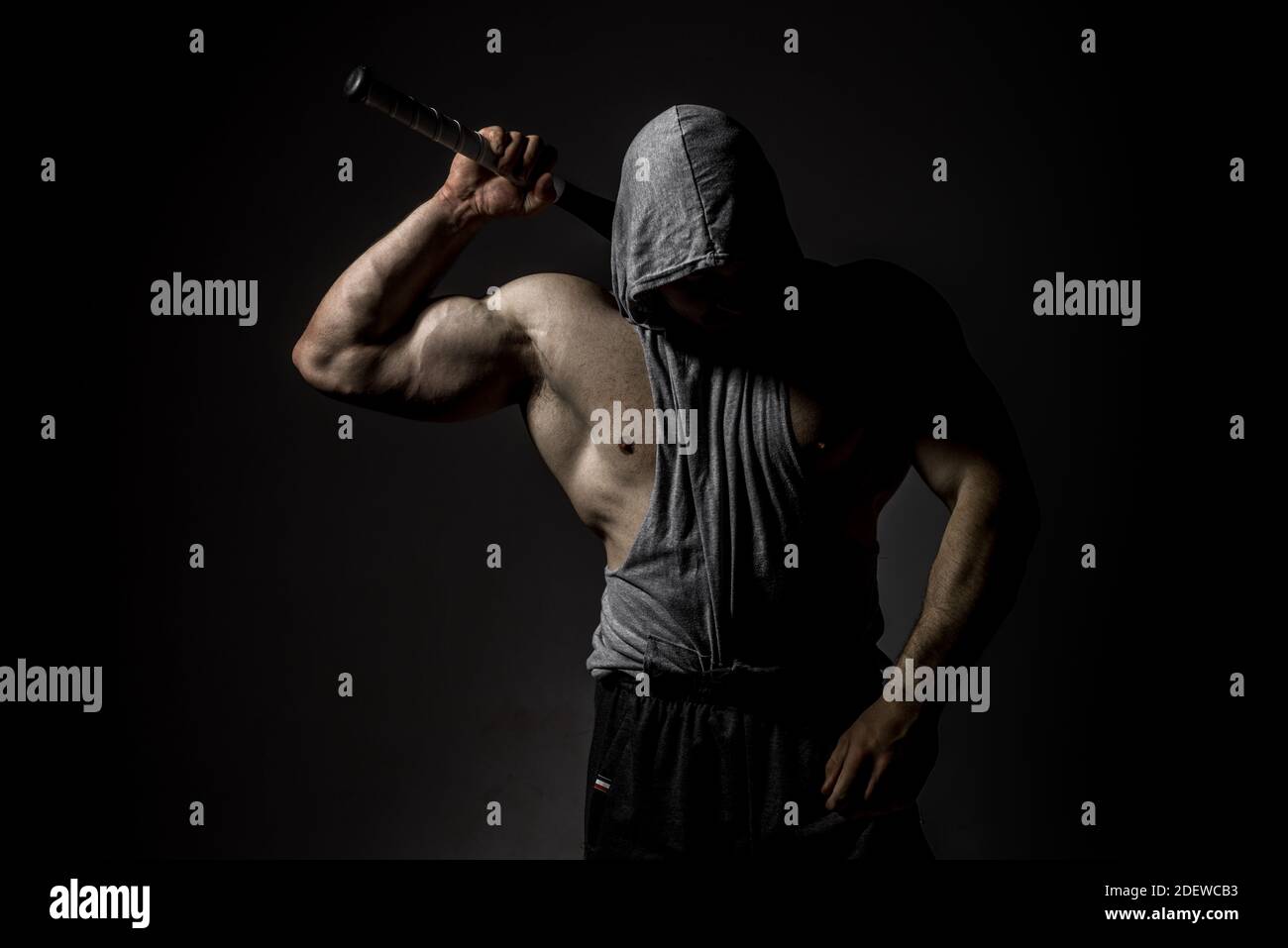 Dangerous muscular man in the mask with baseball bat ready for fight