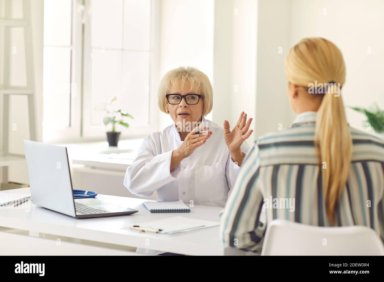 Senior female doctor tells and explains to the patient his diagnosis ...