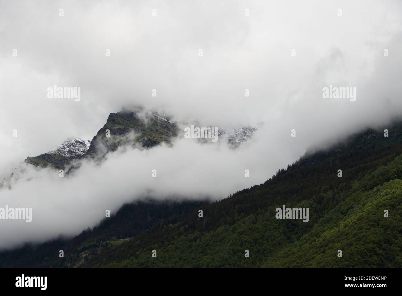 View of rising wafts of mist above the wilderness in the mountains between Chur and Bellinzona in the Swiss Alps Stock Photo