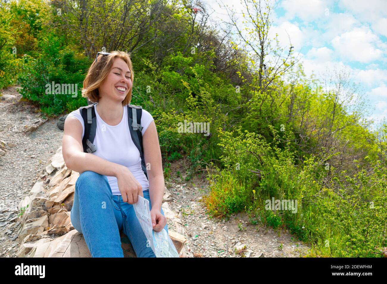A young tourist woman climbed the mountain , and at the top decided to