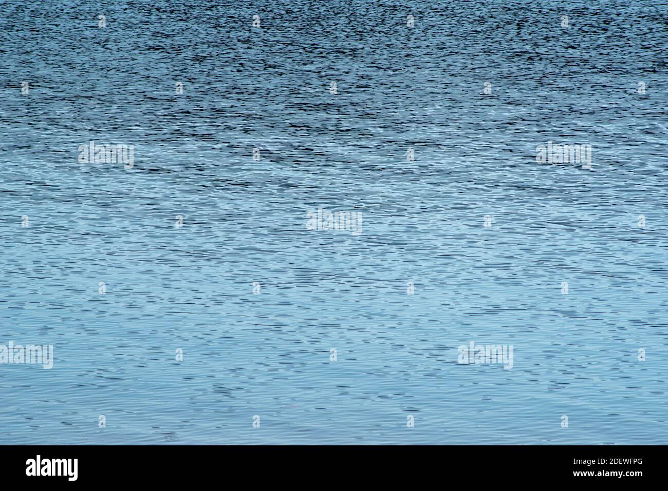 Clear blue water surface with gentle wave patterns Stock Photo
