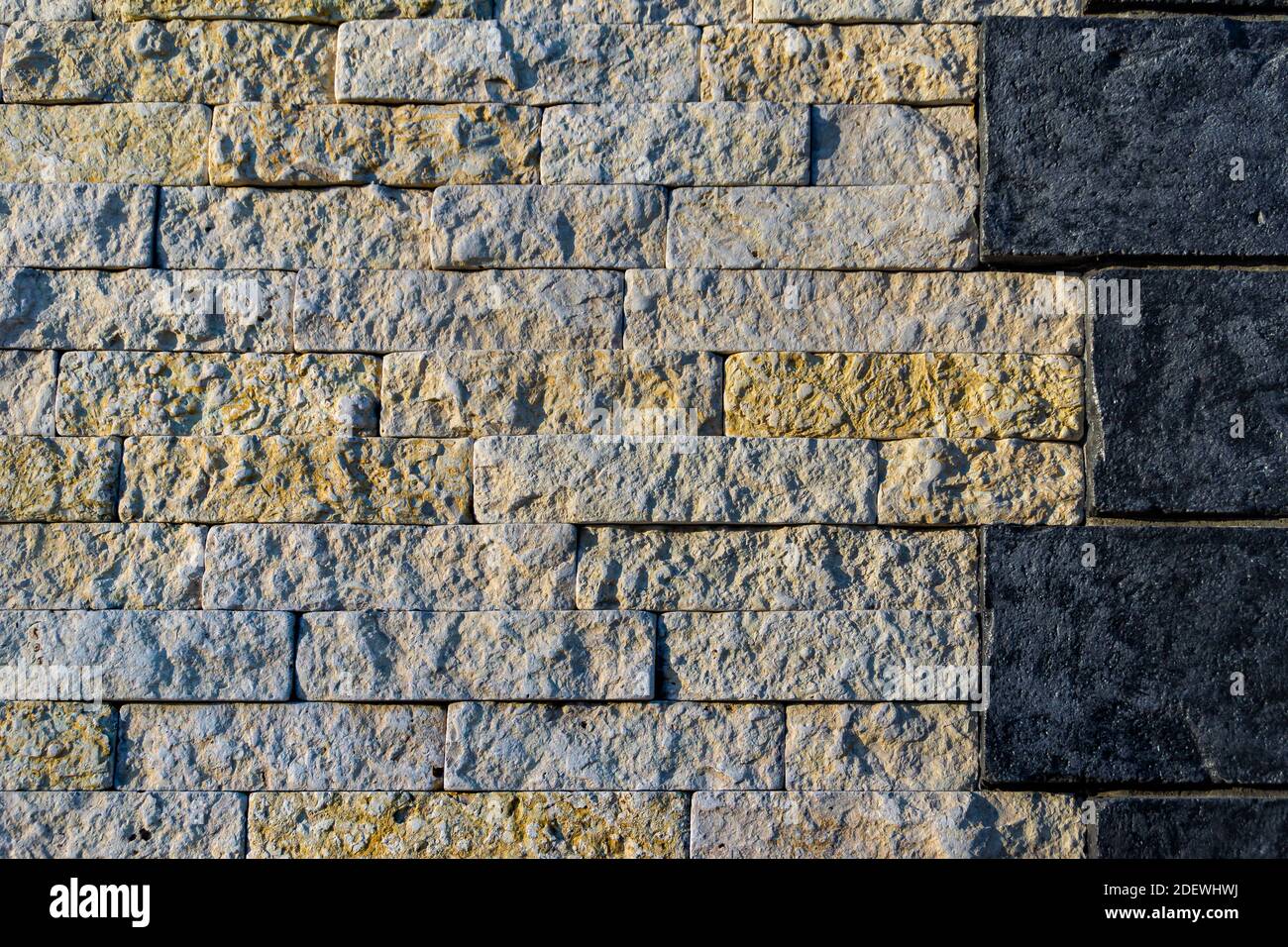 the joint of stone walls of two different types of stone dark and light, large and medium size