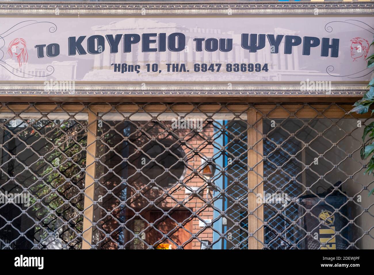 Athens, Greece. November 12, 2020. Barbershop PSIRI at Monastiraki, COVID19 coronavirus lockdown. Traditional old barber salon closed with metal grids Stock Photo