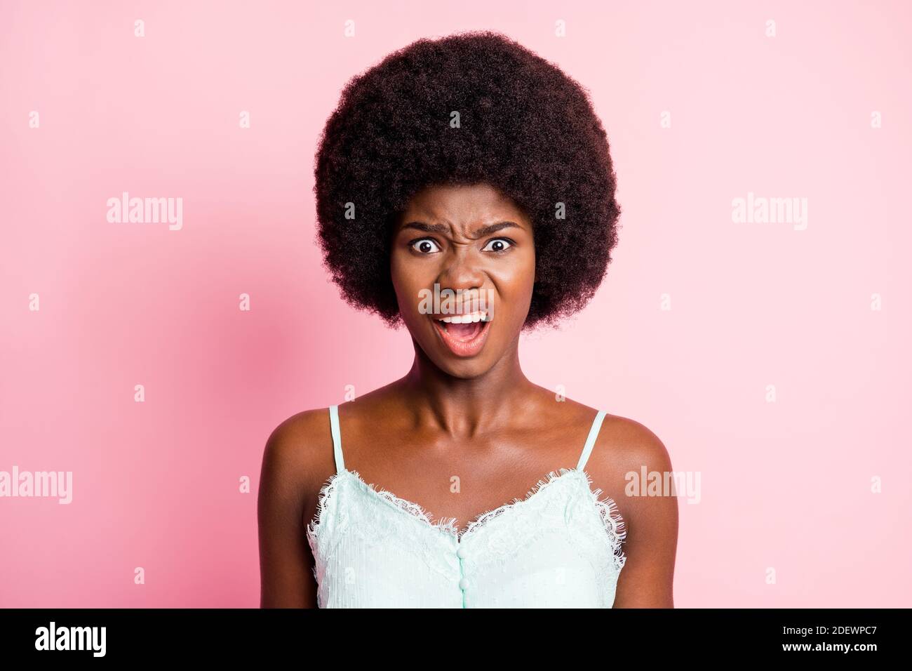 Photo of unhappy shocked young woman make grimace annoyed mood isolated on shine pastel pink color background Stock Photo