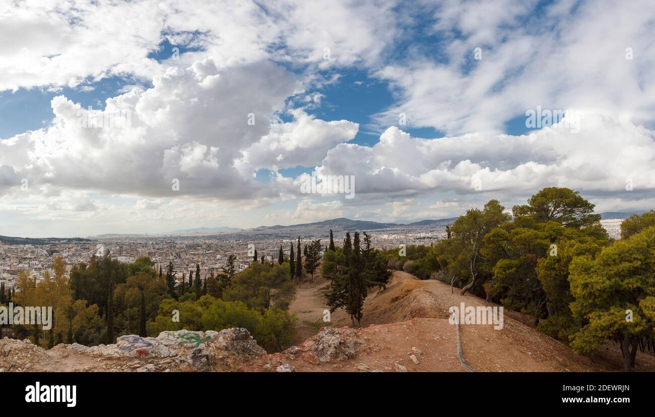 View of Athens from Strefi Hill during a morning with beautiful white clouds. The hill is located in Exarchia district, in Athens, Greece, Europe. Stock Photo