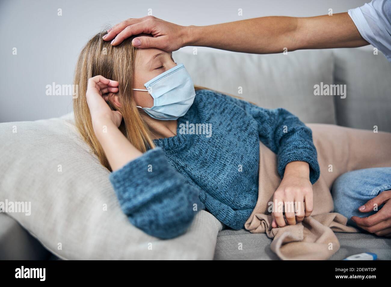 Woman measuring her daughter temperature without a thermometer Stock