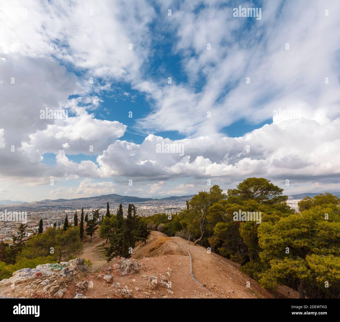 View of Athens from Strefi Hill during a morning with beautiful white clouds. The hill is located in Exarchia district, in Athens, Greece, Europe. Stock Photo