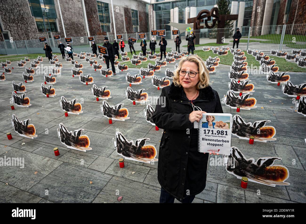 Berlin, Germany. 02nd Dec, 2020. Svenja Schulze (SPD), Federal Minister of the Environment, is holding the collection of a signature campaign with the words "Stop bee deaths" at the protest action "Against the blockade of the insect protection law by the Federal Ministry of Agriculture" in front of the Federal Chancellery. Campact wants to use grave lights and 200 oversized cardboard figures of the Red Mason Bee, an endangered wild bee species, to draw attention to the protection of bees. Credit: Fabian Sommer/dpa/Alamy Live News Stock Photo