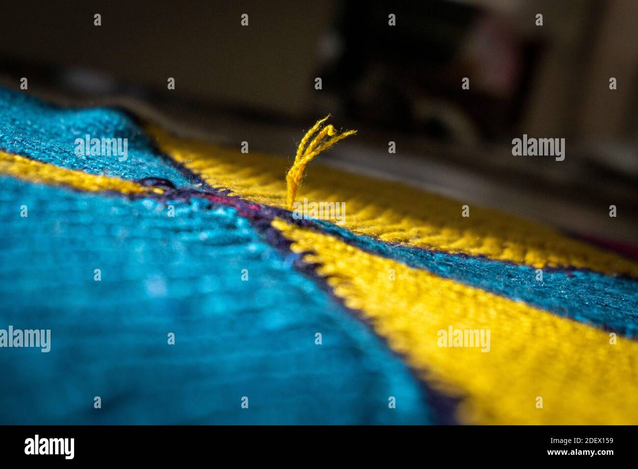 Thread rupture on hand-woven rug. To represent loneliness with rug. Turkish traditional carpet. Stock Photo