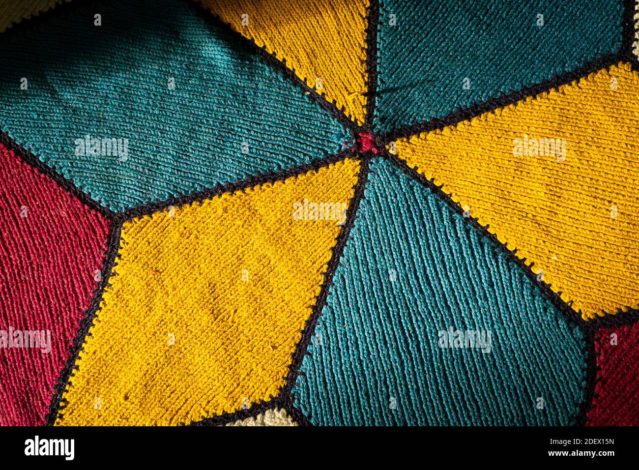 Sunlight comes on the Turkish hand woven rug with shadow. Hand woven rug has yellow,blue,red and white colours. Traditional handmade carpet colourful. Stock Photo