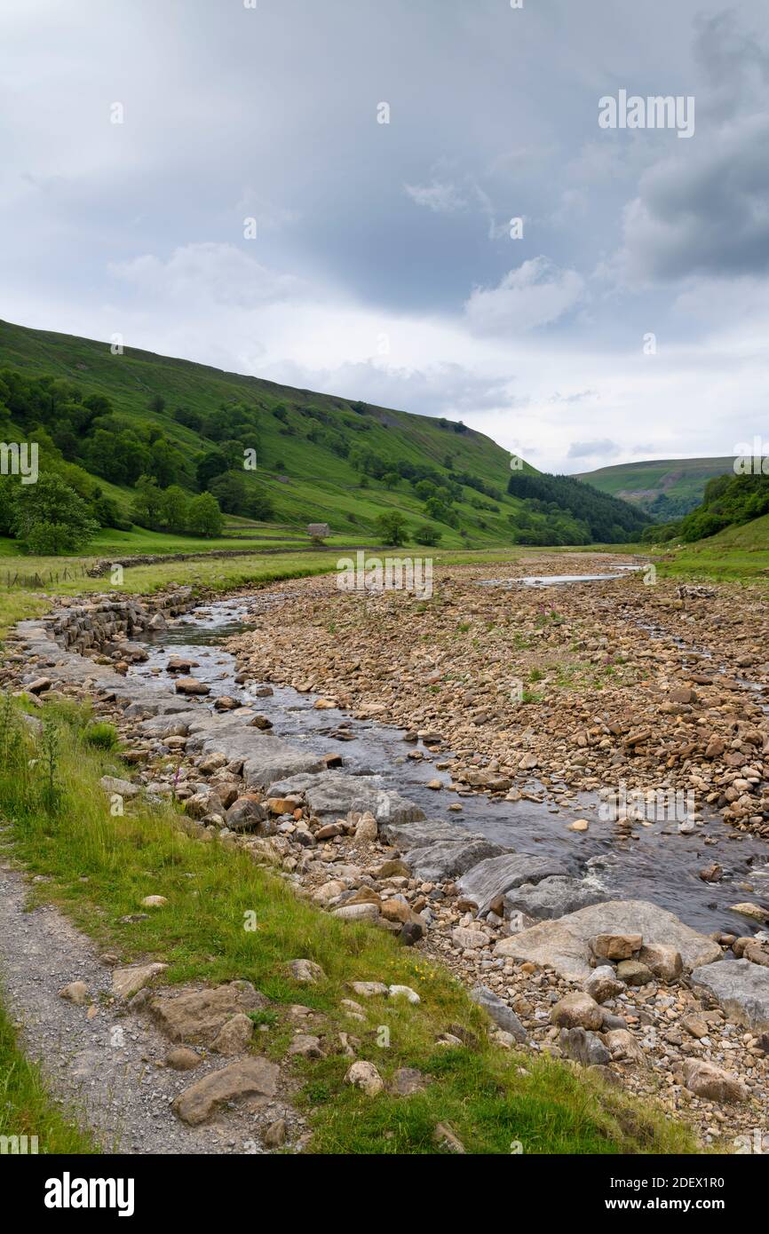 River Swale in scenic countryside valley (low shallow water channel in dry summer weather & riverbed rocks) - Swaledale, Yorkshire Dales, England, UK. Stock Photo