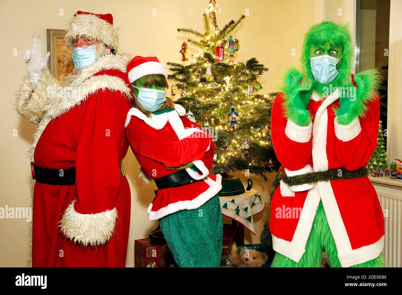 The Weihaftertsmann convinced the Grinch and Mrs. Grinch to wear a protective mask. GEEK ART - Bodypainting and Transformaking: 'The Grinch steals Weihafterten' Photoshooting with Enrico Lein as Grinch, Maria Skupin as Frau Grinch and Fabian Zesiger as Weihaftertmann in the Villa Czarnecki. Hamelin, November 30th, 2020 - A project by the photographer Tschiponnique Skupin and the body painter and transformaker Enrico Lein | usage worldwide Stock Photo