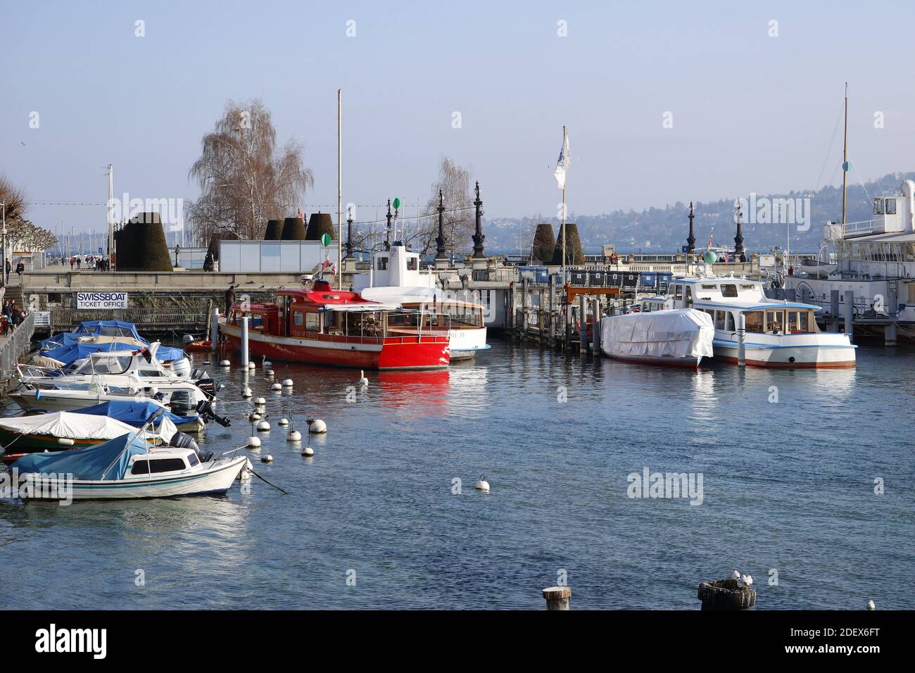 GENEVA, SWITZERLAND - Feb 20, 2018: City trip in Geneva during winter. Picture shows boats on lake with mountains in background. Stock Photo