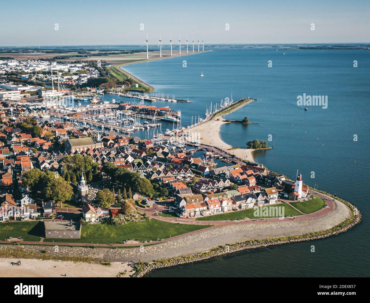 Historic fishing town of Urk in Flevoland, The Netherlands, featuring a lighthouse and a harbor, with wind turbine farm on the background. Popular tou Stock Photo
