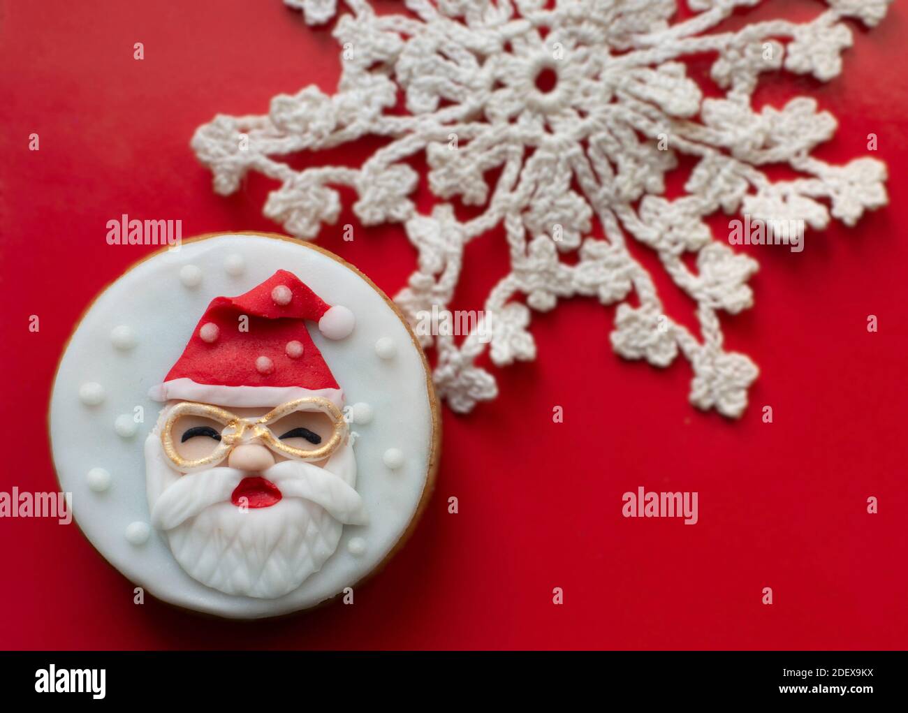 Santa Claus Christmas cookie on red background with blurred crochet ...