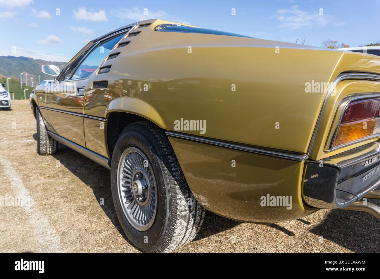 Close up view of the back and side of a gold Alfa Romeo Montreal classic sports coupe outside in sunshine Stock Photo