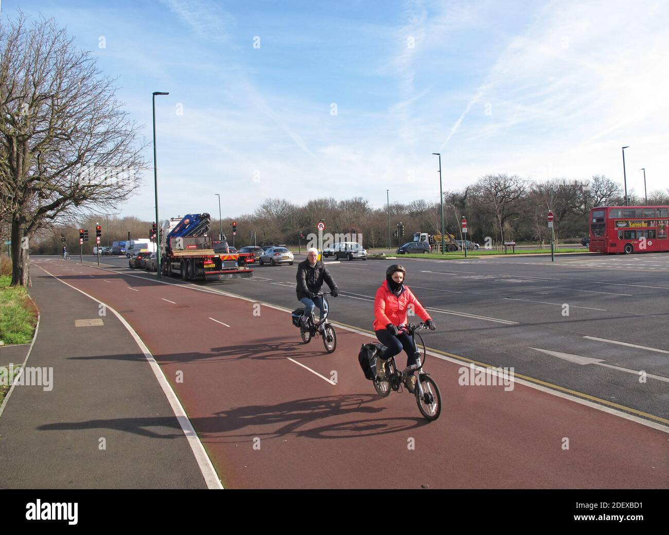 A middle aged couple use the new cycle lane at Whipps Cross roundabout, London. Part of Waltham Forest's 'Mini-Holland' safer streets initiative. Stock Photo