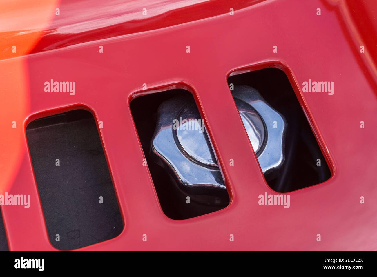 Close up detail of the oil filler cap on a red 1970s Ferrari Dino 246 GT sports car seen through the vent in the engine cover Stock Photo