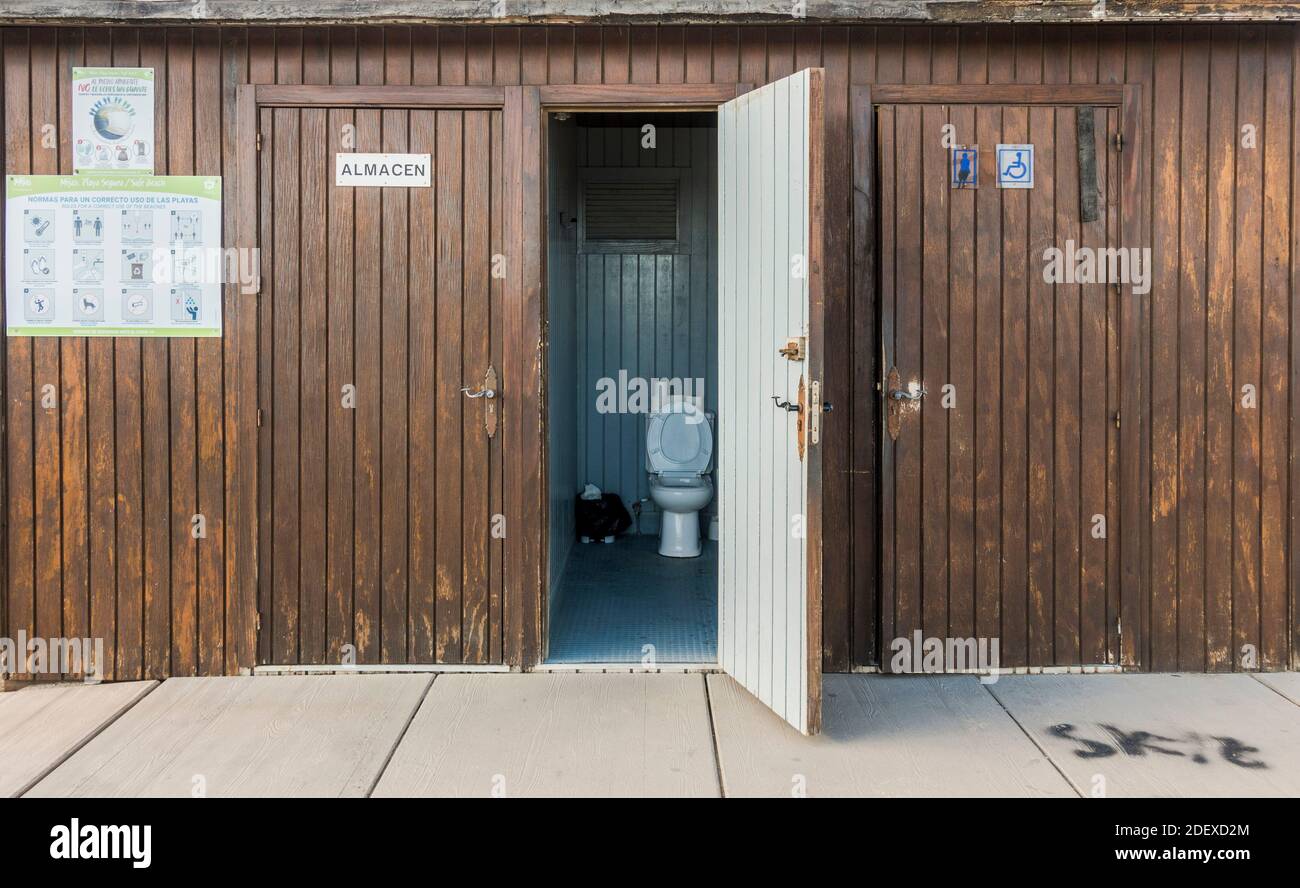 Public toilet, wooden cabins with door open on beach, Spain. Stock Photo