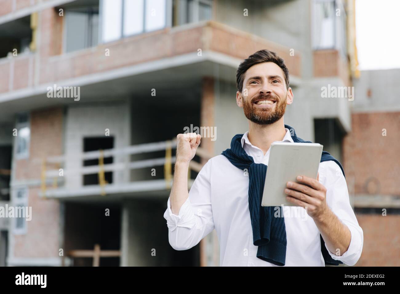 Happy engineer with tablet checking construction process Stock Photo