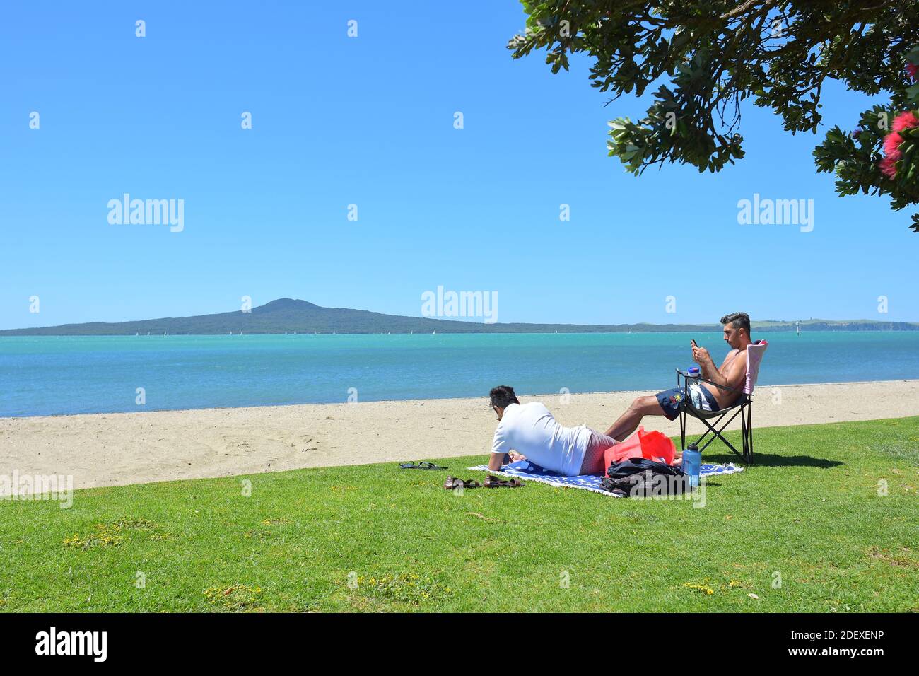 AUCKLAND, NEW ZEALAND - Nov 28, 2020: View of people at St Heliers Bay beach with Rangitoto Island in background Stock Photo