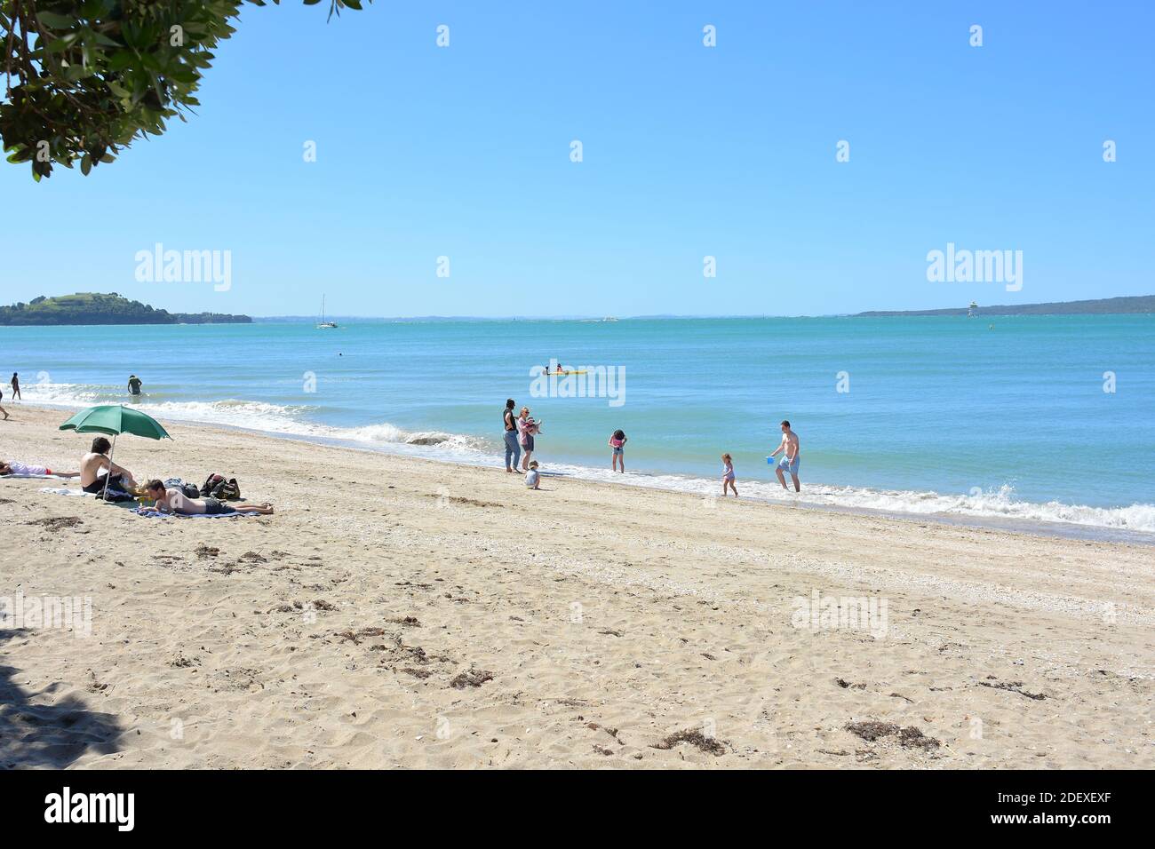 AUCKLAND, NEW ZEALAND - Nov 28, 2020: View of people at Mission Bay beach on sunny weekend day Stock Photo