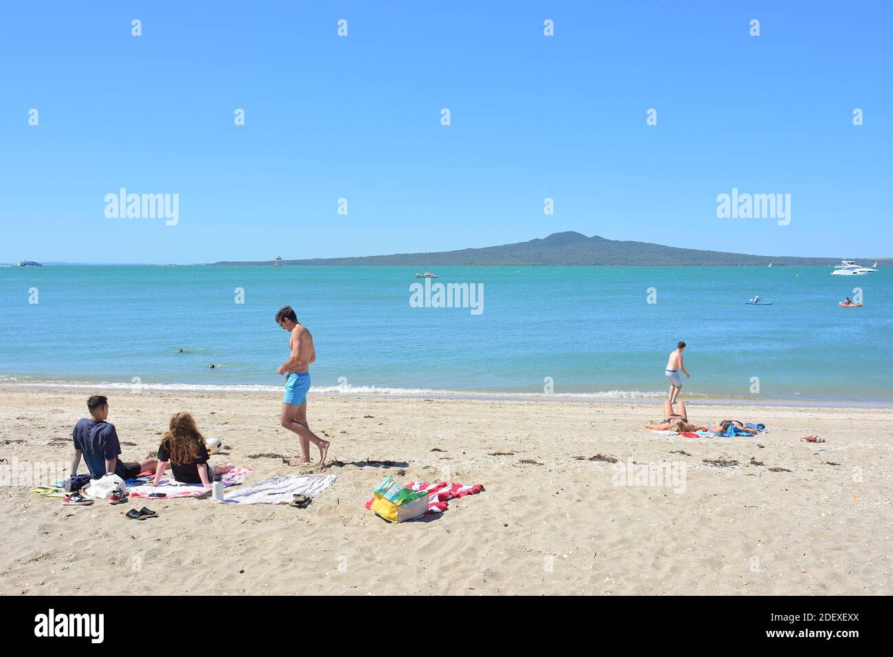 AUCKLAND, NEW ZEALAND - Nov 28, 2020: View of people at Mission Bay beach with Rangitoto Island in background Stock Photo