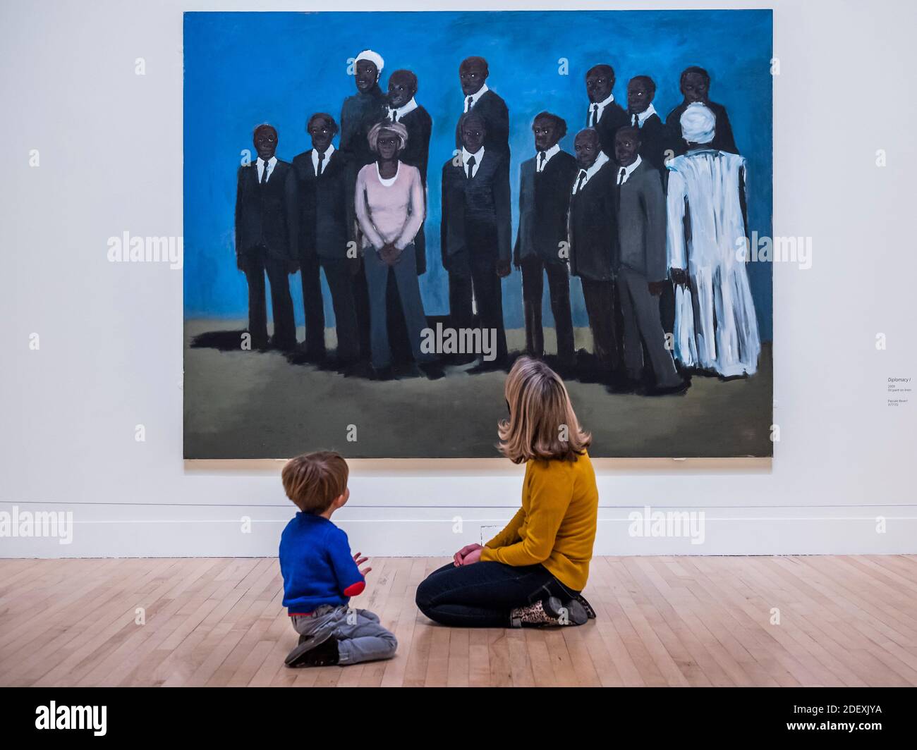 London, UK. 2nd Dec, 2020. A Tate employee gives her 3 year old son and early art lesson with Diplomacy 1, 2009 - Lynette Yiadom-Boakye: Fly In League With The Night at the Tate Britain, as galleries re-open after the second coronavirus lockdown. The first major UK survey exhibition of the British artist brings together over 70 works by one of the most important figurative painters working today, spanning two decades and showcasing their unique ability to concoct human subjects from a composite archive of found images and her own imagination. Credit: Guy Bell/Alamy Live News Stock Photo