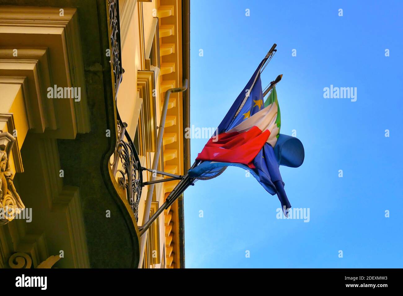 A low angle shot of Italian and EU European Community flags wrapped together Stock Photo
